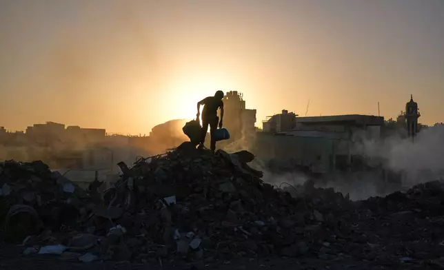 Palestinians search for firewood and plastic at a landfill in Gaza City Saturday, Oct. 25, 2025. (AP Photo/Abdel Kareem Hana)