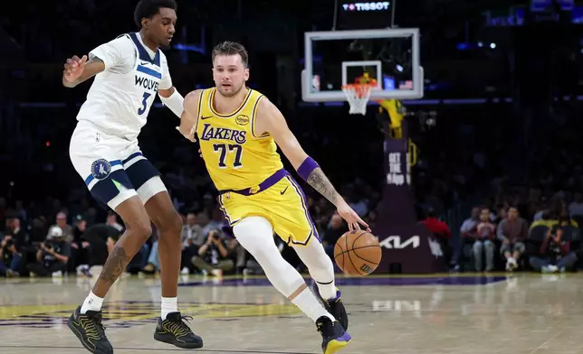 Los Angeles Lakers guard Luka Doncic (77) dribbles against the Minnesota Timberwolves forward Jaden McDaniels (3) during the first half of an NBA basketball game, Friday, Oct. 24, 2025, in Los Angeles. (AP Photo/Jessie Alcheh)