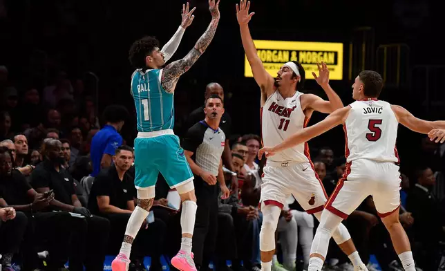Charlotte Hornets guard Lamelo Ball (1) shoots over Miami Heat guard Jaime Jaquez Jr. (11) during the first half of an NBA basketball game, Tuesday, Oct. 28, 2025, in Miami. (AP Photo/Michael Laughlin)