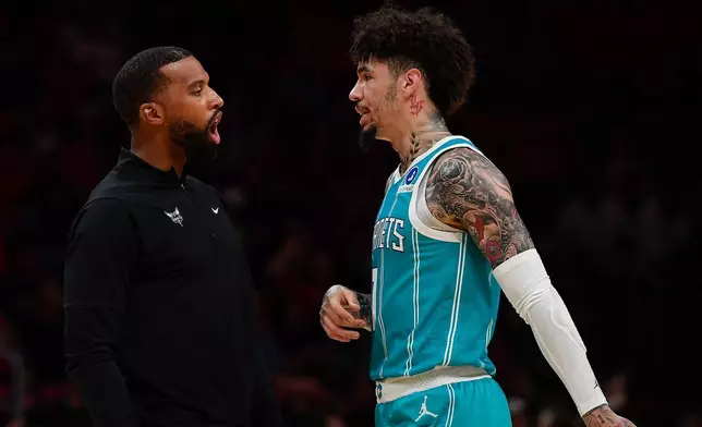 Charlotte Hornets coach Charles Lee talks to LaMelo Ball during the first half of an NBA basketball game against the Miami Heat, Tuesday, Oct. 28, 2025, in Miami. (AP Photo/Michael Laughlin)