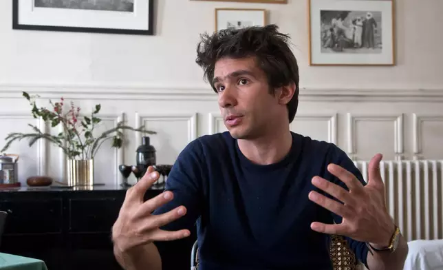 FILE - Lawyer Juan Branco, who co-authored a legal document alleging crimes against humanity by the European Union, speaks during an interview with The Associated Press, April 11 2019, in Paris, France. (AP Photo/Michel Euler, File)