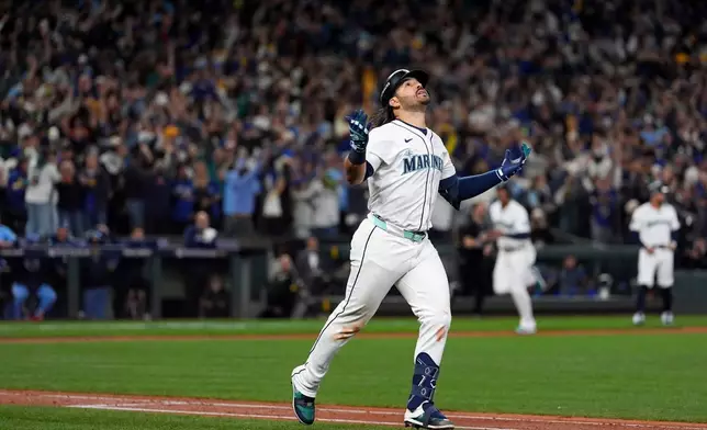 Seattle Mariners' Eugenio Suárez celebrates after hitting a grand slam home run during the eighth inning in Game 5 of baseball's American League Championship Series against the Toronto Blue Jays, Friday, Oct. 17, 2025, in Seattle. (AP Photo/Lindsey Wasson)
