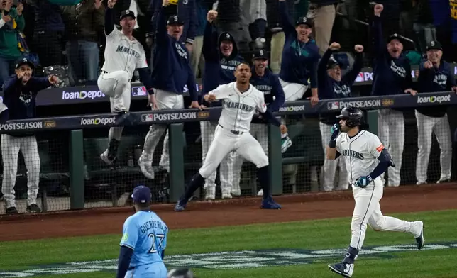 Seattle Mariners' Eugenio Suárez celebrates after hitting a grand slam home run during the eighth inning in Game 5 of baseball's American League Championship Series against the Toronto Blue Jays, Friday, Oct. 17, 2025, in Seattle. (AP Photo/David J. Phillip)