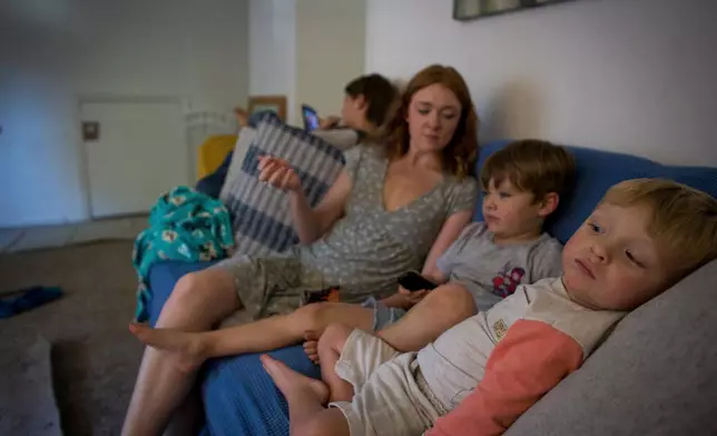 Taylor Moyer, center with her children Liam, from left, Colton, and Bradley at home, Sunday, Oct. 5, 2025, in Virginia Beach, Va. (AP Photo/John Clark)
