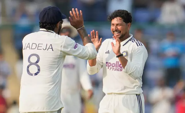 India's Kuldeep Yadav and Ravindra Jadeja celebrate the dismissal of West Indies' Alick Athanaze on the second day of the second cricket test match between India and West Indies at the Arun Jaitley Stadium in New Delhi, India, Saturday, Oct.11, 2025. (AP Photo/Manish Swarup)