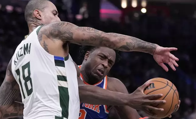 Milwaukee Bucks' Kyle Kuzma fouls New York Knicks' OG Anunoby during the first half of an NBA basketball game Tuesday, Oct. 28, 2025, in Milwaukee. (AP Photo/Morry Gash)
