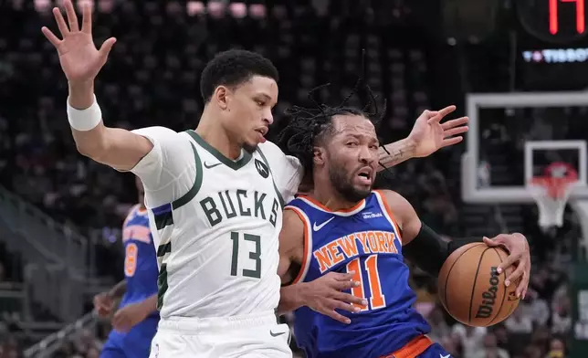 New York Knicks' Jalen Brunson tries to get past Milwaukee Bucks' Ryan Rollins during the first half of an NBA basketball game Tuesday, Oct. 28, 2025, in Milwaukee. (AP Photo/Morry Gash)