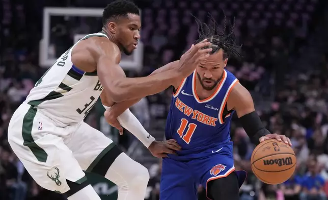 New York Knicks' Jalen Brunson tries to get past Milwaukee Bucks' Giannis Antetokounmpo during the first half of an NBA basketball game Tuesday, Oct. 28, 2025, in Milwaukee. (AP Photo/Morry Gash)