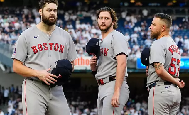 Boston Red Sox pitcher Lucas Giolito, left, walks off the field after player introductions before Game 1 of an American League wild-card baseball playoff series against the New York Yankees, Tuesday, Sept. 30, 2025, in New York. (AP Photo/Yuki Iwamura)
