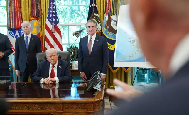 President Donald Trump speaks to reporters before signing an executive order in the Oval Office at the White House, Monday, Oct. 6, 2025, in Washington, as Energy Secretary Chris Wright and Interior Secretary Doug Burgum listen. (AP Photo/Jacquelyn Martin)