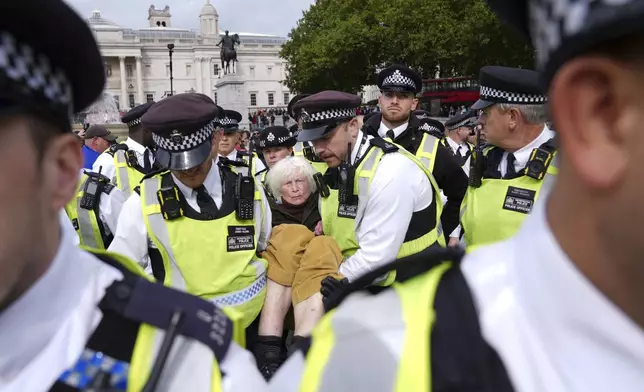 Police remove a protester taking part in a demonstration organised by Defend our Juries, in support of Palestine Action in Trafalgar Square, London Saturday Oct. 4, 2025. (Maja Smiejkowska/PA via AP)