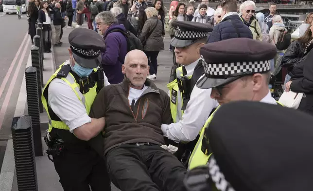 Police remove a protester after a banner was unfurled on Westminster Bridge, London, as part of a demonstration organised by Defend our Juries, in support of Palestine Action, Saturday Oct. 4, 2025. (Stefan Rousseau/PA via AP)