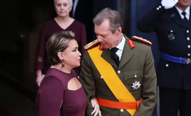 Luxembourg's Grand Duke Henri, right, speaks with Grand Duchess Maria Teresa as they wait for the arrival of guests for the abdication and enthronement ceremony of the Grand Duke of Luxembourg at the Grand Ducal Palace in Luxembourg, Friday, Oct. 3, 2025. (AP Photo/Omar Havana)