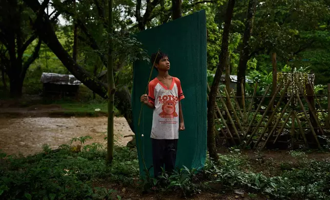 Twelve-year-old Mohama poses for a portrait with his fishing rod along the river that winds past his refugee camp in the Tak province of Thailand, Wednesday, Aug. 27, 2025. (AP Photo/Bram Janssen)