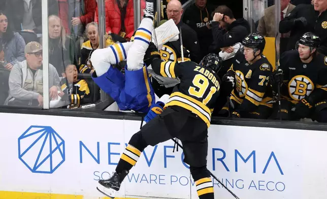 Boston Bruins' Nikita Zadorov (91) checks Buffalo Sabres' Owen Power, center left, during the first period of an NHL hockey game, Saturday, Oct. 11, 2025, in Boston. (AP Photo/Michael Dwyer)