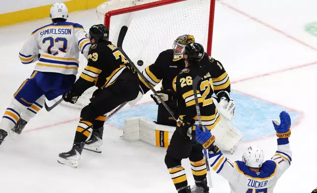Buffalo Sabres' Jason Zucker (17) celebrates after his goal against Boston Bruins' Jeremy Swayman (1) as Bruins' Andrew Peeke (26) and Charlie McAvoy (73) skate away with Sabres' Mattias Samuelsson (23) during the third period of an NHL hockey game, Saturday, Oct. 11, 2025, in Boston. (AP Photo/Michael Dwyer)