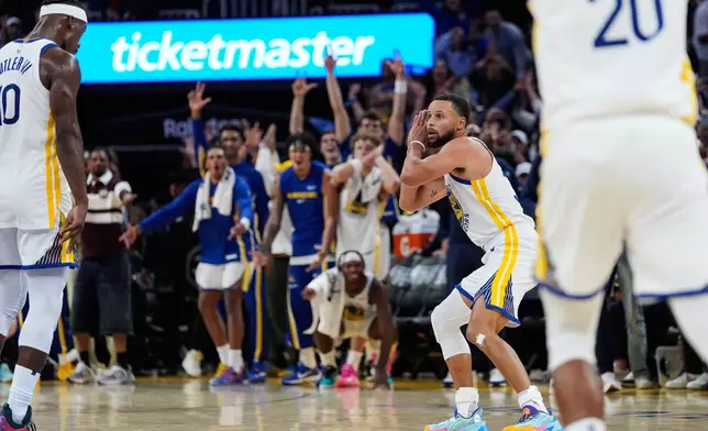 Golden State Warriors guard Stephen Curry (30) gestures toward forward Jimmy Butler III, left, who scored a 3-point basket, during overtime of an NBA basketball game against the Denver Nuggets, Thursday, Oct. 23, 2025, in San Francisco. (AP Photo/Godofredo A. Vásquez)