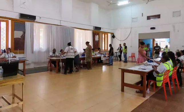 Electoral commission staff monitor as people cast their votes in a runoff presidential election at Mont Fleuri Secondary School, Mont Fleuri, Mahe, Seychelles, Saturday, Oct. 11, 2025. (AP Photo/Emilie Chetty)