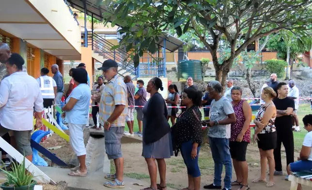 People line up to cast their votes in a runoff presidential election at Mont Fleuri Secondary School, Mont Fleuri, Mahe, Seychelles, Saturday, Oct. 11, 2025. (AP Photo/Emilie Chetty)