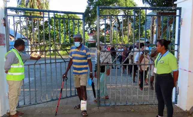 People line up to cast their votes in a runoff presidential election at Mont Fleuri Secondary School, Mont Fleuri, Mahe, Seychelles, Saturday, Oct. 11, 2025. (AP Photo/Emilie Chetty)