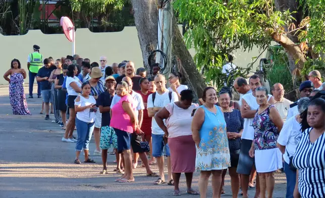 People line up to cast their votes in a runoff presidential election at Mont Fleuri Secondary School, Mont Fleuri, Mahe, Seychelles, Saturday, Oct. 11, 2025. (AP Photo/Emilie Chetty)