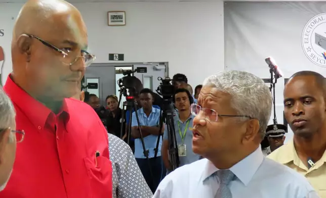 President-elect Patrick Herminie, left, speaks with incumbent leader Wavel Ramkalawan, right, after winning in the runoff presidential election at Mont Fleuri Secondary School polling station in Victoria, Seychelles, on Sunday, Oct. 12, 2025. (AP Photo/Emilie Chetty)
