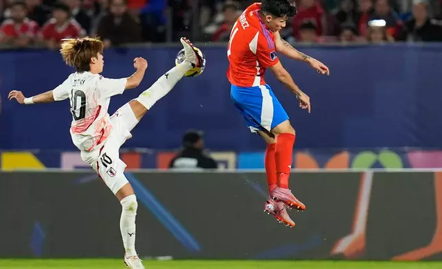 Japan's Yuto Ozeki, left, kicks the ball past Chile's Vicente Alvarez during a FIFA U-20 World Cup Group A soccer match at National Stadium in Santiago, Chile, Tuesday, Sept. 30, 2025. (AP Photo/Matias Delacroix)