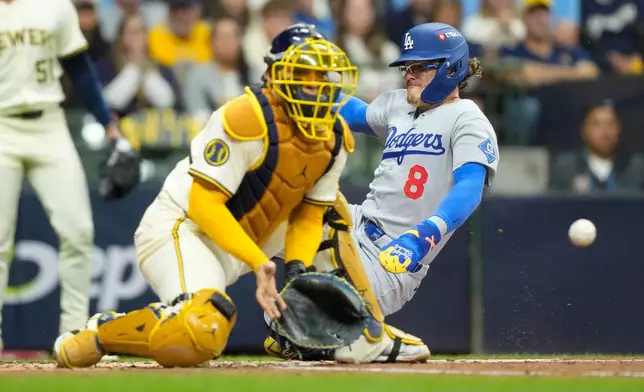 Los Angeles Dodgers' Enrique Hernández scores past Milwaukee Brewers catcher William Contreras on a double by Andy Pages during the second inning in Game 2 of baseball's National League Championship Series, Tuesday, Oct. 14, 2025, in Milwaukee. (AP Photo/Brynn Anderson)