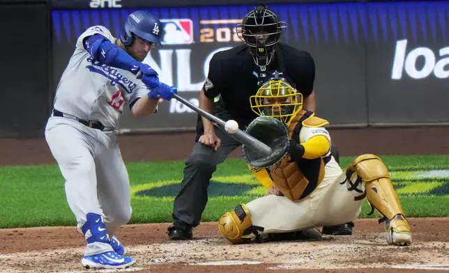 Los Angeles Dodgers' Max Muncy hits a home run during the sixth inning of Game 2 of baseball's National League Championship Series against the Milwaukee Brewers Tuesday, Oct. 14, 2025, in Milwaukee. (AP Photo/Morry Gash)