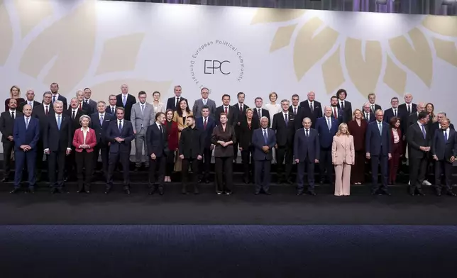 Ukrainian President Volodymyr Zelenskyy, front row center left, speaks to French President Emmanuel Macron as he stands with Denmark's Prime Minister Mette Frederiksen and other heads of state, including Italian Premier Giorgia Melon, front row fourth from right, Poland's Prime Minister Donald Tusk, right, European Commission President Ursula von der Leyen, Spain's Prime Minister Pedro Sanchez, fourth from left, during a family photo at the European Political Community summit, in Copenhagen, Thursday, Oct. 2, 2025. (Suzanne Plunkett/Pool Photo via AP)