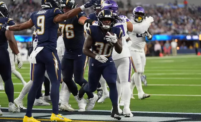 Los Angeles Chargers running back Kimani Vidal (30) scores a touchdown during the first half of an NFL football game against the Minnesota Vikings Thursday, Oct. 23, 2025, in Inglewood, Calif. (AP Photo/Gregory Bull)
