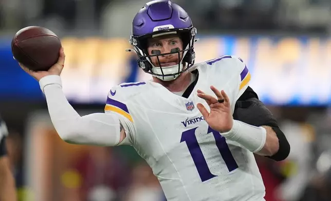 Minnesota Vikings quarterback Carson Wentz (11) passes during the first half of an NFL football game against the Los Angeles Chargers Thursday, Oct. 23, 2025, in Inglewood, Calif. (AP Photo/Gregory Bull)