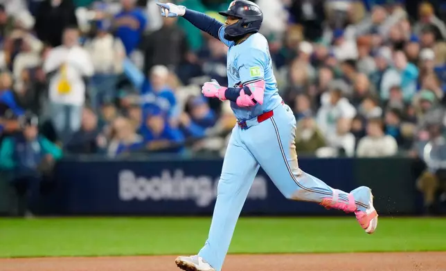 Toronto Blue Jays' Vladimir Guerrero Jr. (27) celebrates while rounding the bases after hitting a solo home run against the Seattle Mariners during fifth inning Game 3 American League Championship Series baseball action in Seattle on Wednesday, Oct. 15, 2025. (Frank Gunn/The Canadian Press via AP)