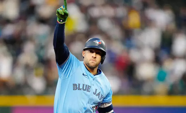 Toronto Blue Jays' George Springer (4) celebrates while rounding the bases after hitting a solo home run against the Seattle Mariners during fourth inning Game 3 American League Championship Series baseball action in Seattle on Wednesday, Oct. 15, 2025. (Frank Gunn/The Canadian Press via AP)