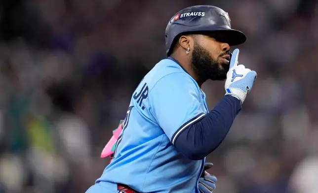 Toronto Blue Jays' Vladimir Guerrero Jr. celebrates his solo home run against the Seattle Mariners during the fifth inning in Game 3 of baseball's American League Championship Series, Wednesday, Oct. 15, 2025, in Seattle. (AP Photo/David J. Phillip)