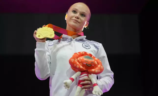 Individual Neutral Athlete Angelina Melnikova holds the gold medal after winning the Women's All-Around Final during the 53rd Artistic Gymnastics World Championships in Jakarta, Indonesia, Thursday, Oct. 23, 2025. (AP Photo/Dita Alangkara)