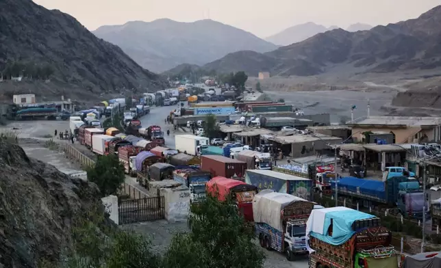 A line of cargo trucks bound for Pakistan is stranded on the Afghan side of the Torkham border crossing, which remained closed after clashes, in Nangarhar province, Afghanistan, Tuesday, Oct. 14, 2025. (AP Photo/Wahidullah Kakar)