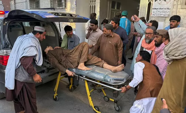 People bring a man, who was injured in the clashes between Pakistan and Afghan forces in border area, for medical treatment at a hospital in Chaman, a town on the Pakistan side of the border, Wednesday, Oct. 15, 2025. (AP Photo/H. Achakzai)