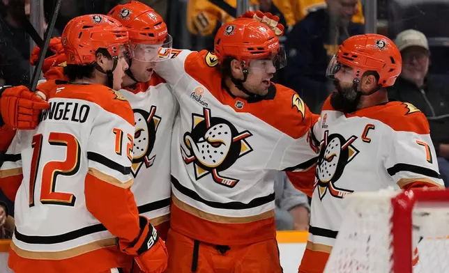 Anaheim Ducks left wing Ross Johnston, second from left, celebrates his goal with right wing Sam Colangelo (12), center Ryan Poehling, second from right, and defenseman Radko Gudas (7) during the first period of an NHL hockey game against the Nashville Predators, Tuesday, Oct. 21, 2025, in Nashville, Tenn. (AP Photo/George Walker IV)