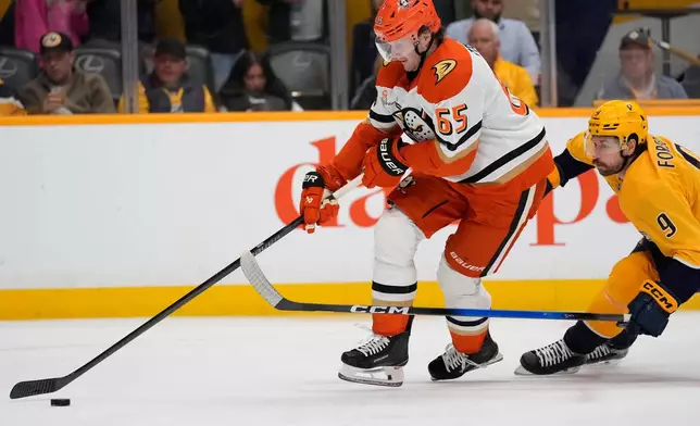 Anaheim Ducks defenseman Jacob Trouba (65) moves the puck past Nashville Predators left wing Filip Forsberg (9) during the second period of an NHL hockey game Tuesday, Oct. 21, 2025, in Nashville, Tenn. (AP Photo/George Walker IV)