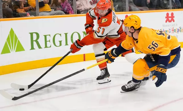 Anaheim Ducks defenseman Olen Zellweger (51) and Nashville Predators left wing Erik Haula (56) chase the puck during the second period of an NHL hockey game Tuesday, Oct. 21, 2025, in Nashville, Tenn. (AP Photo/George Walker IV)