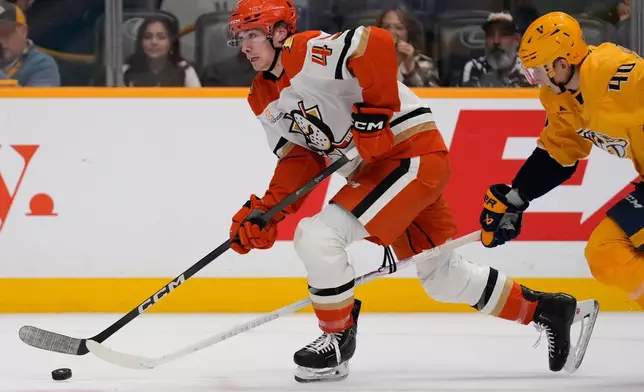 Anaheim Ducks right wing Beckett Sennecke (45) moves the puck past Nashville Predators center Fedor Svechkov (40) during the first period of an NHL hockey game Tuesday, Oct. 21, 2025, in Nashville, Tenn. (AP Photo/George Walker IV)