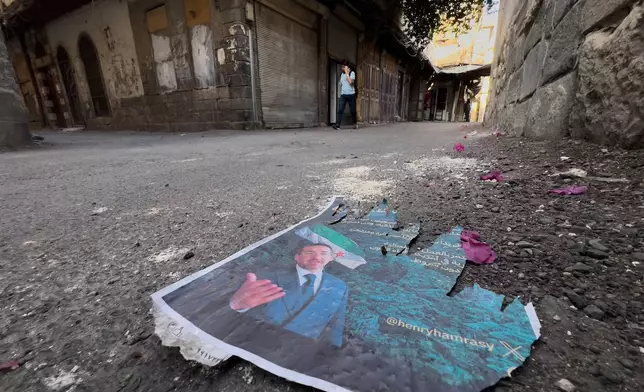 A torn poster of Syrian-American Jew Henry Hamra, a candidate for the Syrian parliamentary elections, lies on the ground at the Jewish neighborhood in old Damascus, Syria, Friday, Oct. 3, 2025. (AP Photo/Hussein Malla)