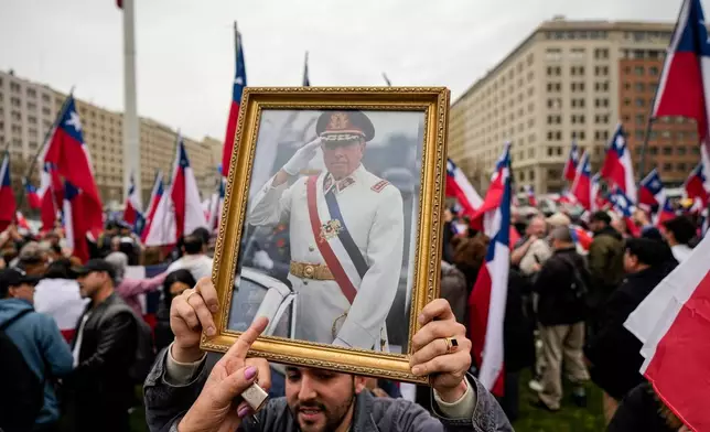 FILE - A group in favor of Gen. Augusto Pinochet celebrate the 50th anniversary of a military coup led by Pinochet, near La Moneda presidential palace, in Santiago, Chile, Sept. 9, 2023. (AP Photo/Esteban Felix, File)