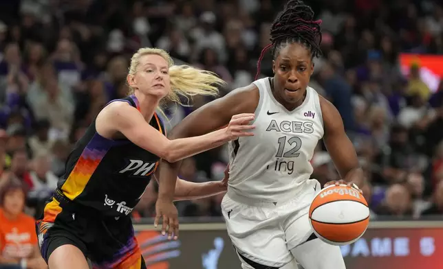 Las Vegas Aces guard Chelsea Gray (12) drives past Phoenix Mercury guard Lexi Held, left, during the first half of Game 4 of the WNBA basketball finals, Friday, Oct. 10, 2025, in Phoenix. (AP Photo/Rick Scuteri)