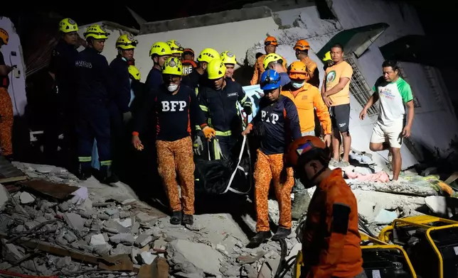 Rescuers bring down a body they recovered from the ruins of a collapsed building, Wednesday, Oct. 1, 2025 after a strong earthquake struck Bogo city, Cebu Province, Central Philippines. (AP Photo/Aaron Favila)