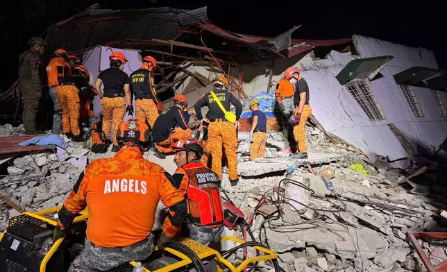 Rescuers search for survivors underneath rubble in Bogo, Philippines, Wednesday, Oct. 1, 2025. (AP Photo/Aaron Favila)