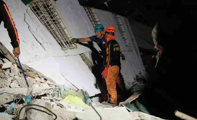 Rescuers check for survivors from the ruins of a collapsed building, Wednesday, Oct. 1, 2025 after a strong earthquake struck Bogo city, Cebu Province, Central Philippines. (AP Photo/Aaron Favila)