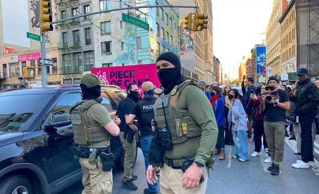Federal agents conduct an immigration sweep on Canal Street in Chinatown as protestors gather, Tuesday, Oct. 21, 2025, in New York. (AP Photo/Jake Offenhartz)