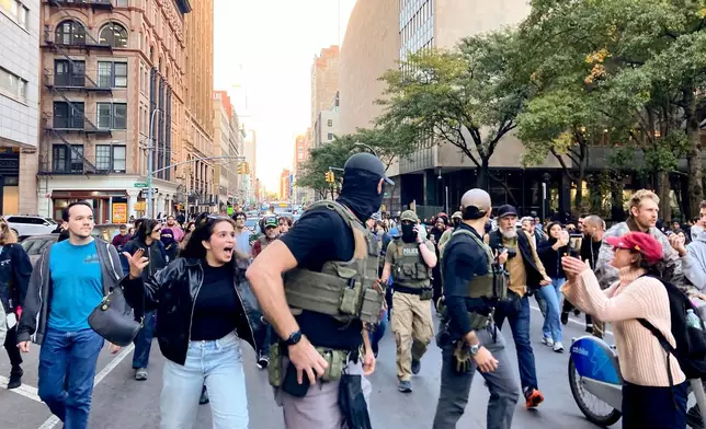 Protestors confront Federal agents as they walk down Lafayette Street after an immigration sweep on Canal Street through Chinatown, Tuesday, Oct. 21, 2025, in New York. (AP Photo/Jake Offenhartz)